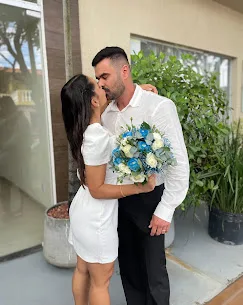 Casal com buquê de flores azuis e brancas