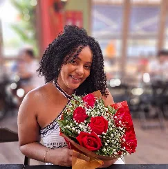 Cliente sorrindo com buquê de rosas
