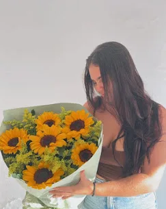 Cliente com buquê de girassóis