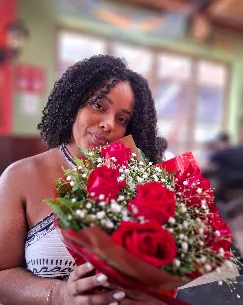 Cliente com buquê de rosas vermelhas