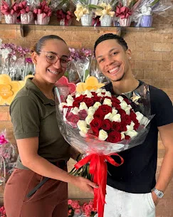 Cliente recebendo buquê de rosas na loja Gisa Flores