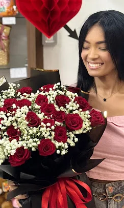 Cliente com buquê de rosas vermelhas e brancas